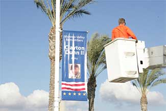 Workman lowering himself after installing a banner